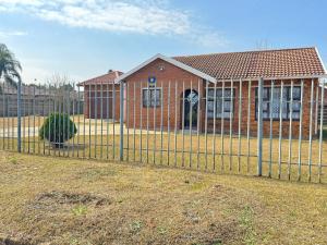 a fence in front of a brick house at Indalo Guesthouse in Vryheid