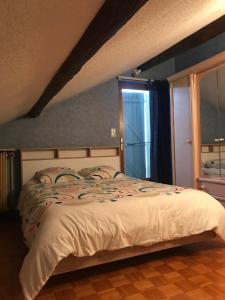 ein Schlafzimmer mit einem Bett und einem großen Fenster in der Unterkunft Maison au pied du Beaujolais in Saint-Georges-de-Reneins