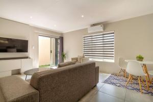 ein Wohnzimmer mit Sofa und Tisch in der Unterkunft #AlimamaSpaces Culross Cottage Retreat in Johannesburg