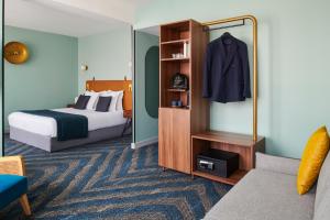 une chambre d'hôtel avec un lit et un miroir dans l'établissement Maison des Ambassadeurs, à La Rochelle