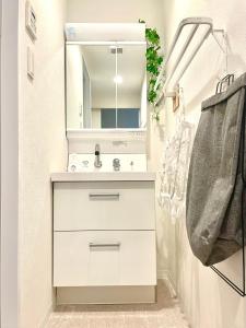 een witte badkamer met een wastafel en een spiegel bij Modern Tokyo Suites in Tokyo +127 foto's