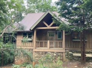 a house in the woods with a porch at Sapphire Cabin at Splendor Mountain in Tiger