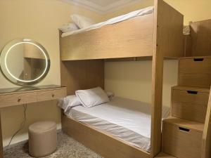 a bedroom with two bunk beds and a mirror at شاليه بقرية كورال هيلز الساحل الشمالي برأس الحكمة in Jalāl +18 photos