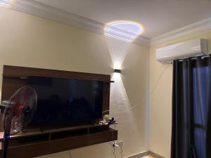 a living room with a flat screen tv and a fan at شاليه بقرية كورال هيلز الساحل الشمالي برأس الحكمة in Jalāl