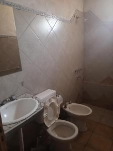 a bathroom with a toilet and a sink at Don QUITERIO in Abdón Castro Tolay