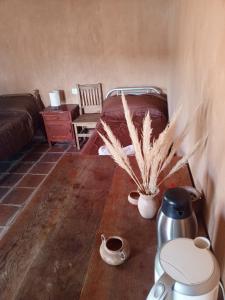 a room with a bed and a table with a plant at Don QUITERIO in Abdón Castro Tolay