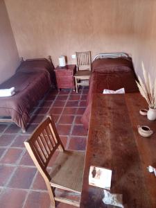 a room with two beds and a table and chairs at Don QUITERIO in Abdón Castro Tolay