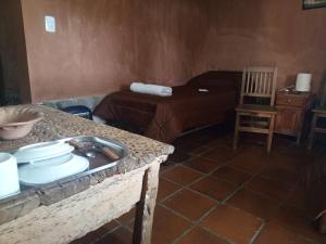 a room with a bed and a table with dishes on it at Don QUITERIO in Abdón Castro Tolay