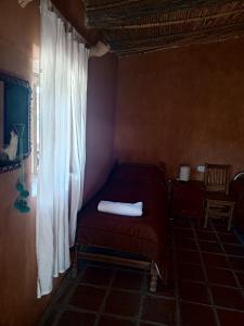a small bedroom with a bed and a window at Don QUITERIO in Abdón Castro Tolay
