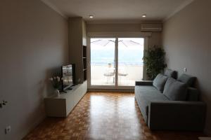 a living room with a couch and a large window at Casa do Alto in Amarante