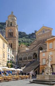 a large building with a clock tower and a fountain at Casa MAR e LUNA in Amalfi