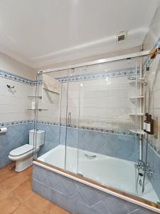 a bathroom with a shower and a tub and a toilet at Gibraltar Views Guest House in La Línea de la Concepción +27 photos