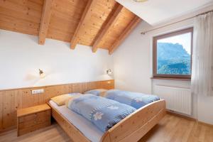 zwei Betten in einem Schlafzimmer mit Fenster in der Unterkunft Rungghof in Wengen