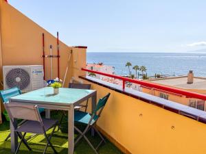 a table and chairs on a balcony with the ocean at Blue Ocean Oasis in Puerto de Santiago