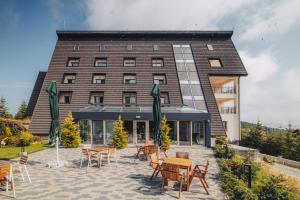 珀尔蒂尼什La MOONte的一座前面有桌椅的建筑物