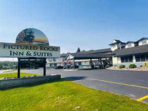 een bord voor een herberg met suites op een parkeerplaats bij Pictured Rocks Inn and Suites in Munising