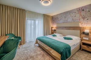 a hotel room with a bed and a desk and chair at La MOONte in Păltiniş +36 photos