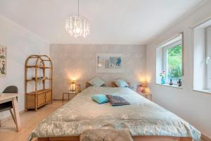 a bedroom with a bed and a desk and a chandelier at Bei Annemarie in Trier