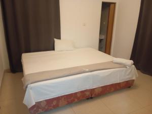 Bett in einem Zimmer mit weißer Bettwäsche und Kissen in der Unterkunft Apart, Monte in Beira