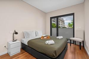 a bedroom with a large bed and a window at Rooftop Pools & Balcony Haven by HostWise in Faro
