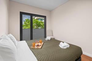 a bedroom with a bed with a tray of food on it at Rooftop Pools & Balcony Haven by HostWise in Faro