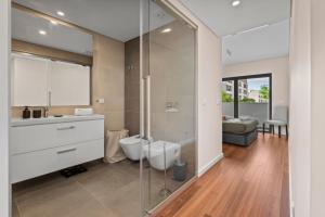 a bathroom with a shower and a toilet and a sink at Rooftop Pools & Balcony Haven by HostWise in Faro +32 photos