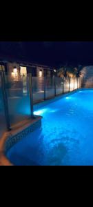 une grande piscine avec de l'eau bleue la nuit dans l'établissement Casa CNH 1, à Santiago del Estero