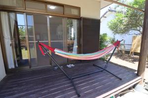 a hammock on the porch of a house at おどろき荘 in Shirako