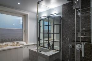 a bathroom with a glass shower and a sink at Sönshörn 16 in Munkmarsch +49 photos