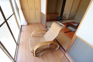 a wicker chair in a room with a mirror at おどろき荘 in Shirako