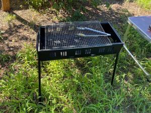 a grill with tongs on it sitting in the grass at おどろき荘 in Shirako +87 photos