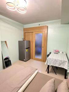 a living room with a refrigerator and a table at Kathys Crib Family Suite Room at Shell Residence in Manila