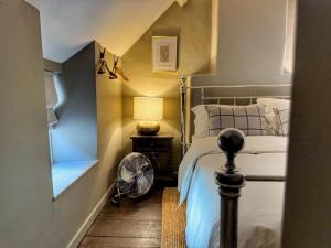 ein kleines Schlafzimmer mit einem Bett und einem Ventilator in der Unterkunft Well Cottage, Thames St in Charlbury