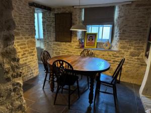 ein Esszimmer mit einem Holztisch und Stühlen in der Unterkunft Well Cottage, Thames St in Charlbury + 9 Fotos