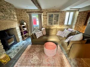ein Wohnzimmer mit Couch und Kamin in der Unterkunft Well Cottage, Thames St in Charlbury