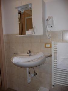 łazienka z białą umywalką i lustrem w obiekcie Hotel Cantore w Genui