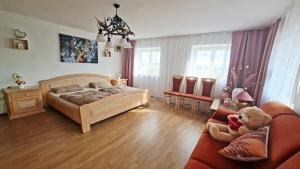 a bedroom with a bed and a teddy bear at Hengeler's hof in Altusried