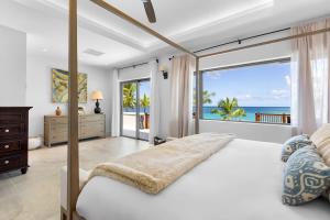 a bedroom with a bed with a view of the ocean at Newly Renovated Notos Cove Villa Property in Love