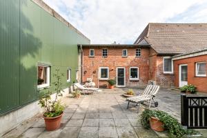 an outdoor patio with chairs and tables and buildings at Deichblick in Wesselburenerkoog