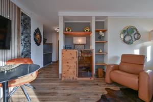a living room with a couch and a table and a chair at Ferienwohnung am König Ludwig Resort in Schwangau