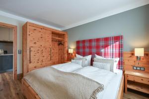 a bedroom with a large bed with a wooden headboard at Ferienwohnung am König Ludwig Resort in Schwangau