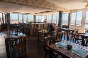 a woman sitting at a table in a restaurant at Hotel Le Pousse Pousse in Antananarivo