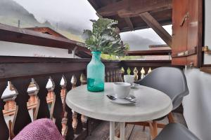 un tavolo con un vaso e 2 sedie sul balcone di Appartements Cafe Schneider a Sankt Anton am Arlberg