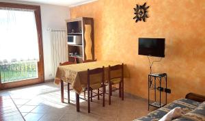 a living room with a table and a tv at Pink Grumello in Schilpario