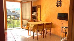 a dining room with a table with chairs and a window at Pink Grumello in Schilpario