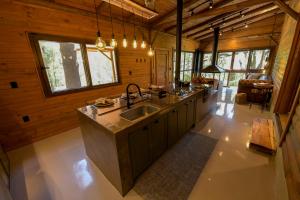 a kitchen in a log cabin with a sink at Cabana Rústica em Gramado in Gramado +72 photos