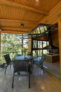 a patio with a table and chairs and a bed at Cabana Rústica em Gramado in Gramado