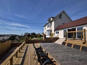 インストウにある11 Bed in Instow REDLAの家の屋根の上に椅子が置かれた木製のデッキ