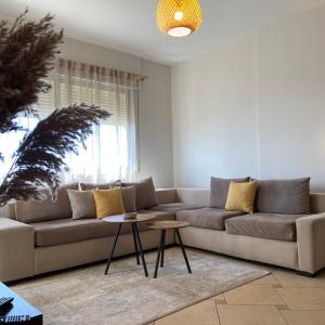 a living room with a couch and a table at Fole Maison in Durrës