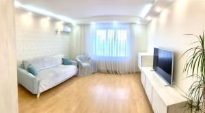 a living room with a couch and a television at Apartment near the center Затишна квартира в центрі in Sumy